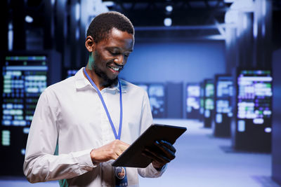 Side view of young man using mobile phone in office