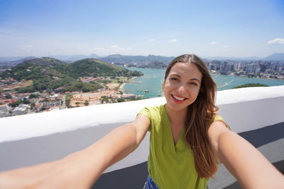 Brazilian young traveler woman takes selfie in vila velha, espirito santo state, brazil