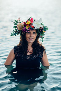 Portrait of woman wearing flowers in sea