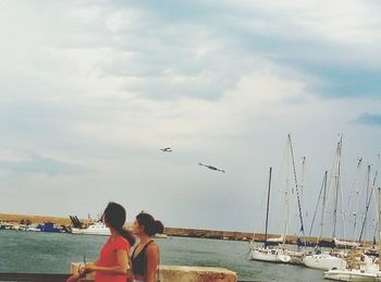 Rear view of a girl flying over sea