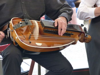 Midsection of man playing guitar