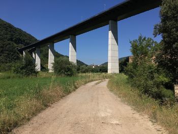 Road by bridge against clear sky