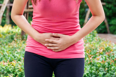 Midsection of woman touching plant