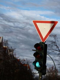 Low angle view of road signal against sky