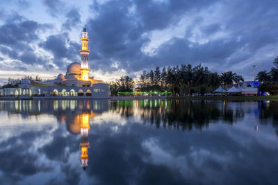 Reflection of illuminated building in lake at dusk