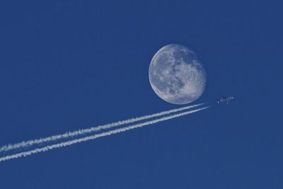 Low angle view of moon against clear blue sky