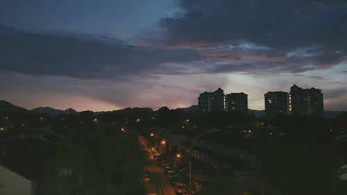 Aerial view of illuminated city against sky at dusk