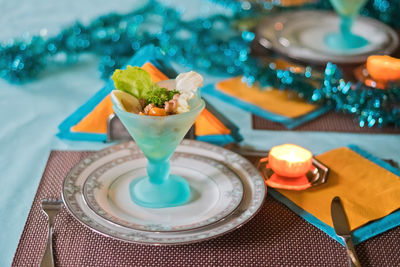 Festively served table, anticipation of christmas, sea salad in turquoise bowls