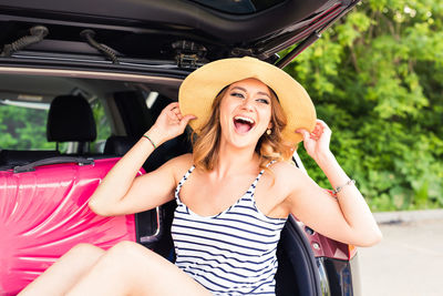 Portrait of happy woman sitting in car