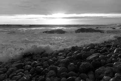 Pebbles on beach against sky