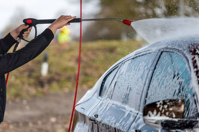 Midsection of man washing car