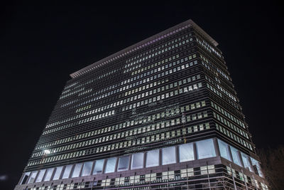 Low angle view of modern building against sky at night