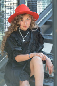 Portrait of young woman sitting in hat