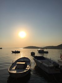 Boats in sea at sunset