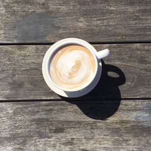 High angle view of coffee cup on wooden table