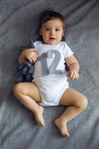 Portrait of cute baby boy sitting on sofa at home