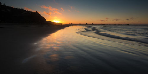 Scenic view of beach against sky during sunset