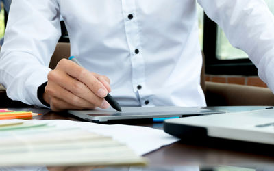 Midsection of man working on table