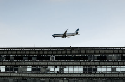 Low angle view of airplane flying against clear sky