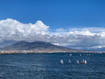 Scenic view of sea and snowcapped mountains against blue sky