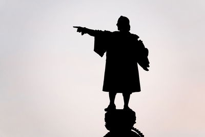 Silhouette man standing against clear sky during sunset