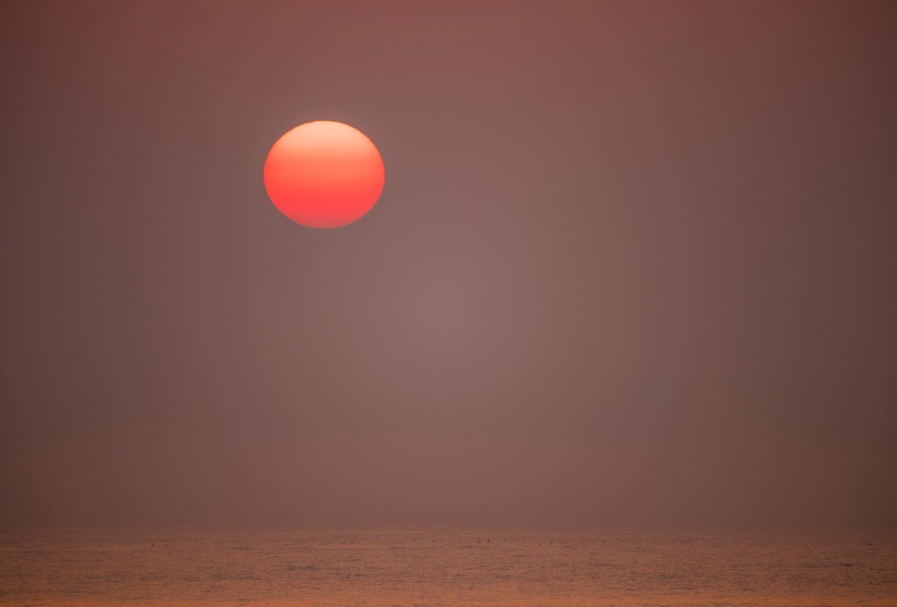 SCENIC VIEW OF SUN AGAINST ORANGE SKY