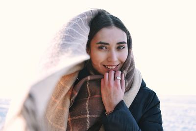 Portrait of smiling woman wearing scarf during winter