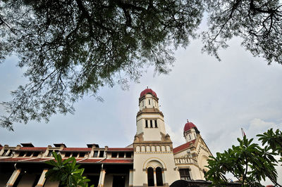 Low angle view of building and trees against sky