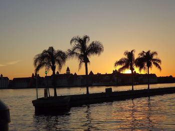 Silhouette palm trees against clear sky during sunset