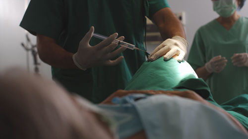 Midsection of doctor examining patient
