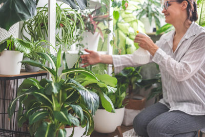 Low section of woman holding potted plants