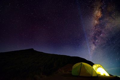 Low angle view of illuminated tent against sky at night