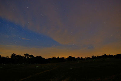 Scenic view of silhouette field against sky at night