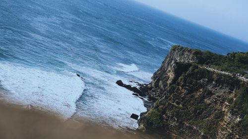 High angle view of rocks on beach against sky