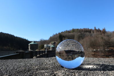 Close-up of crystal ball against clear blue sky