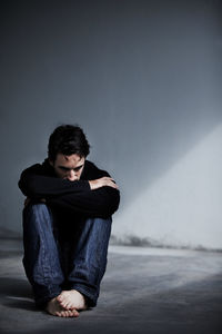 Depressed man sitting on floor