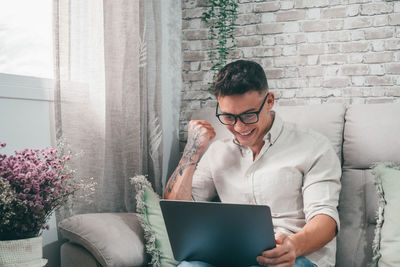 Young woman using laptop while sitting at home