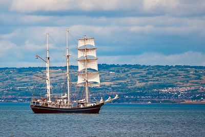 Sailboat sailing on sea against sky