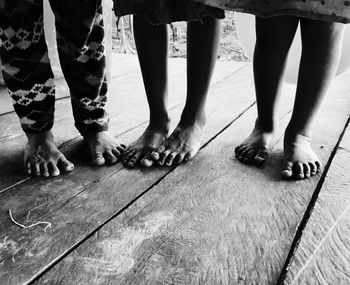 Low section of people standing on wooden floor