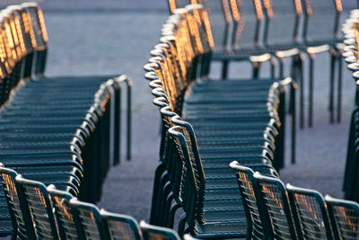 Empty chairs on footpath during sunset