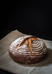 Close-up of bread on table against black background