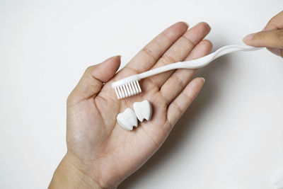 Close-up of hand holding hands over white background