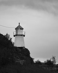 Lighthouse by sea against sky