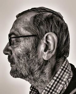 Close-up of senior man against white background