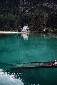 Scenic view of lake by building against trees