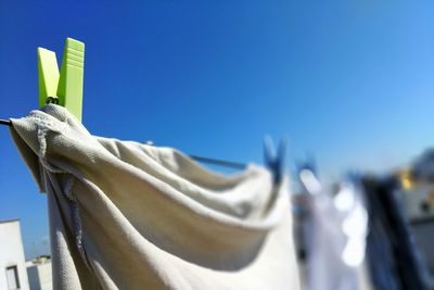 Low angle view of clothes drying against blue sky