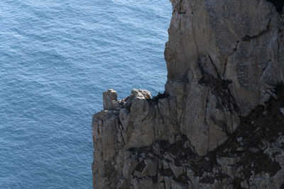 Rock formation by sea against sky