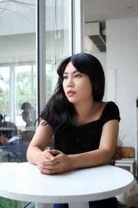 Portrait of young woman sitting on table