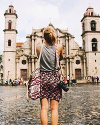 Rear view of woman standing in front of building