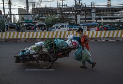 Rear view of people riding motorcycle on road